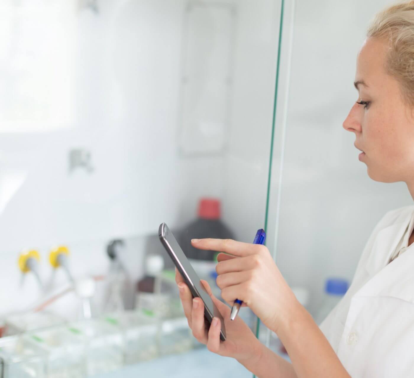 Woman Using Mobile Phone to Track Assets in Lab